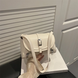 Chic cream white PU leather crossbody bag with flap and decorative zippers on white book