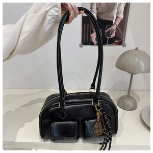 Detailed view of black Boston bag featuring dual front pockets and tennis racket pendant