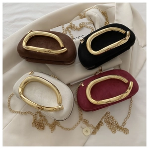 Detail view of four velvet capsule clutch bags in brown, black, white, and burgundy colors
