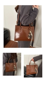 Détail du sac cabas marron en similicuir avec breloques et bandoulière amovible