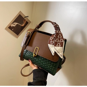 Detail of green woven leather and brown smooth texture with silk scarf handle