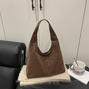 Brown leopard print suede tote bag in hobo style on a cozy knit blanket