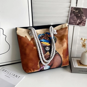 Close-up of artistic ethnic female print and woven cotton rope handles on canvas tote