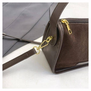 Detail of dark brown matte suede and smooth leather stitching with gold hardware accents