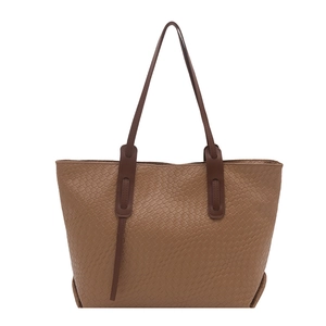 Borsa tote marrone con trama intrecciata e spalline scure su sfondo bianco