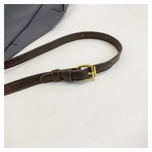 Detail of dark brown leather strap with adjustable gold buckle and refined stitching