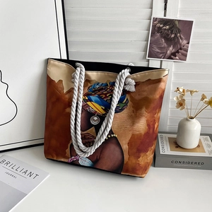 Close-up of woven cotton rope handles and colorful African art print on canvas tote bag