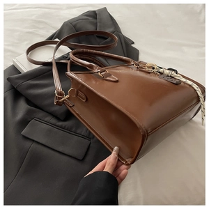 Détail du cabas vintage en cuir PU marron avec nœud tressé et bandoulière amovible