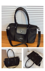 Macro detail of large black nylon tote bag with leather flap closure and removable strap