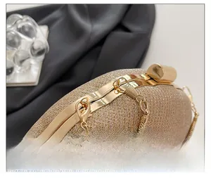 Close-up of golden metallic lock and high-gloss chain detail on sparkling evening clutch