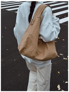Back view of a khaki oversized crescent moon bag with crinkled nylon texture on model