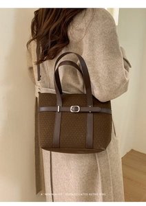 Detailed texture of dark brown woven fabric with leather strap and silver metal buckle