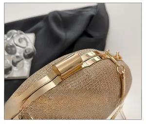 Detailed close-up of golden hardware clasp and sequined fabric on an evening bag