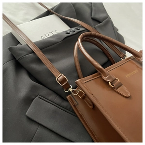 Détail d'un sac cabas en similicuir marron avec texte Fashion & Bags et anses rondes