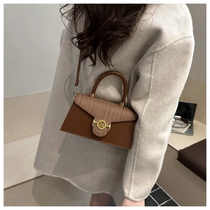 Detailansicht der Vintage-Beige-Webtasche mit braunem Lederbesatz und goldener M-Schließe