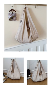 Detail view of beige minimalist large capacity tote bag with side zipper and knotted puller
