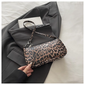 Close-up of leopard print baguette bag with textured faux leather and silver metal hooks
