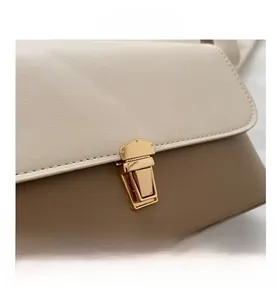 Detail of color-block flap handbag showing premium leather texture and golden metal lock