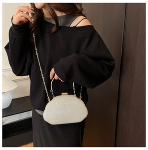 Detailed view of champagne gold evening clutch with glitter sequins and metal chain