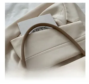 Detailed view of elegant beige leather handbag handle with minimalist office styling