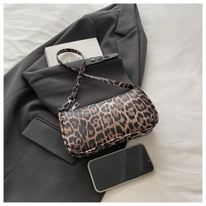 Detailed top view of leopard print baguette bag on a grey blazer showing texture