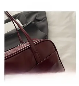 Detailed macro view of wine red pillow bag showing zipper closure and stitching crafts