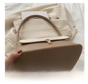 Detailed bottom view and side stitching of the khaki and cream two-tone shoulder bag