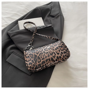 Detailed close-up of leopard print baguette bag texture on a grey blazer background