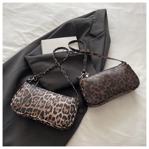 Detail view of two stylish leopard print baguette bags in brown and beige PU leather texture