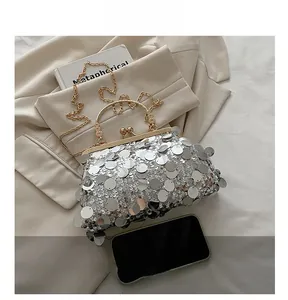 Sequin shell evening bag featuring a gold chain and vintage metal handle for gala events