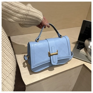 Sky blue quilted cross-body bag with golden metal buckle and top handle details