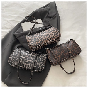 Three leopard print baguette underarm bags in brown and grey tones on grey fabric