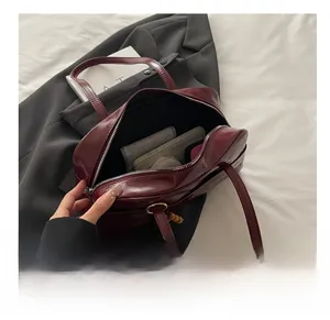 Internal view of burgundy leather tote showing large capacity with zipper and beads