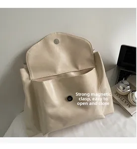 Detail of beige tote bag internal structure with magnetic closure and front pocket