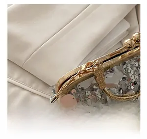Macro view of sparkly silver sequins and golden clasp detail on the evening clutch bag