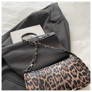 Close-up of leopard print shoulder bag with silver hardware on a gray blazer
