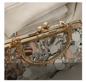Close-up of sparkling silver and gold sequins with elegant metal spherical lock on evening bag