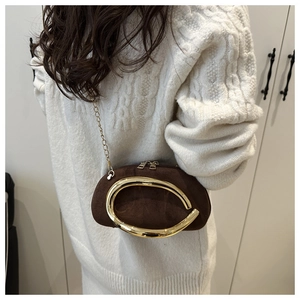 Détail d'un mini sac bandoulière en daim marron avec anneau doré et bandoulière chaîne