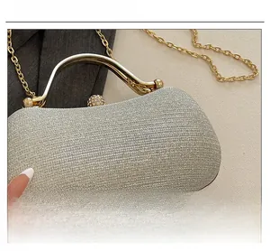 Macro detail of silver glitter fabric with gold metal handle and rhinestone closure