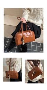 Detailed view of brown leather tote bag with colorful wooden beads and a glossy finish