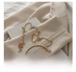 Detail view of silver sequin evening bag with gold ring handle and chain strap on blazer