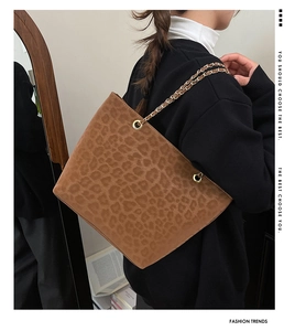 Detailed macro view of leopard print tote bag featuring soft suede texture and gold chain strap