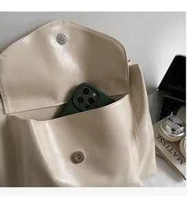 Detail of the front pocket showing storage for a smartphone in a beige tote bag