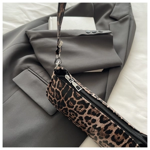 Detailed view of leopard print underarm bag with silver zipper and leather texture
