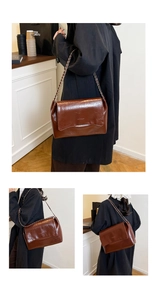 Détail d'un sac bandoulière vintage en cuir huilé marron avec chaîne et texte embossé