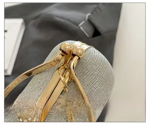 Detail of silver glitter evening clutch featuring a gold crystal ball clasp and chain