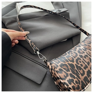 Close-up of leopard print shoulder bag featuring a detachable silver metal hook buckle