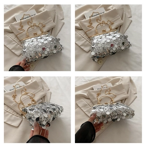 Detail of silver sequined evening bag with golden hardware and metallic clasp closure