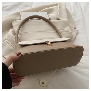 Détail d'un sac à main minimaliste beige et kaki avec boucle métallique dorée élégante