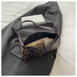 Internal view of leopard print shoulder bag showing wallet and cosmetic essentials